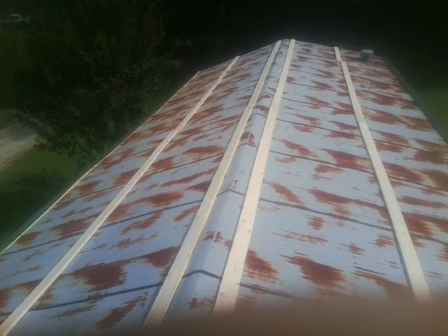 Rusted metal roof panels with new wood purlins before replacement — Storm Damage Roof Repair in Radcliffe by Roofing Brothers